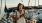 woman texts near a boat at a pier