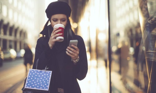 Close to the center of everything woman looking at her phone on city sidewalk