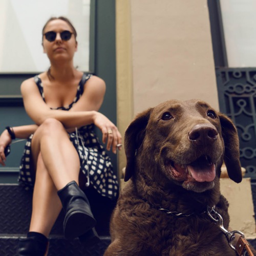 woman and her dog sitting outside a building