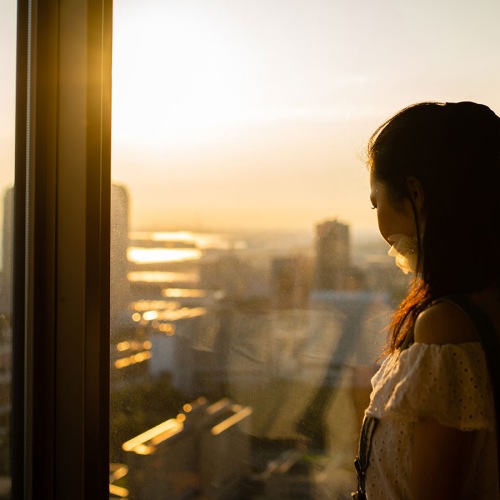 woman looking out a window at city views