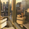 a woman sitting in a chair with large windows