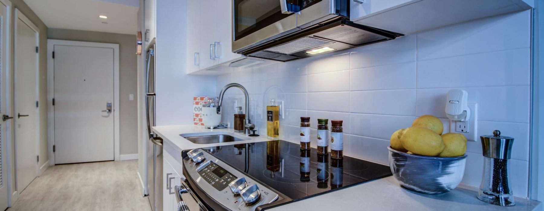 a kitchen with a microwave oven and a bowl of fruit